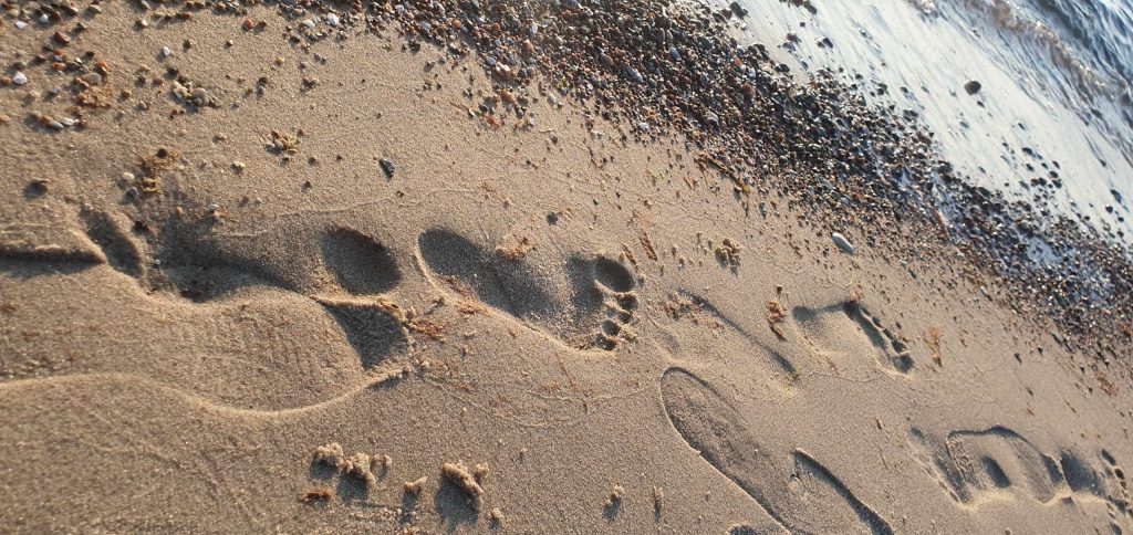 Fußspuren am Strand mit Meer